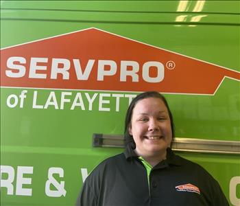 Young woman with dark hair, standing in front of a green Servpro work vehicle